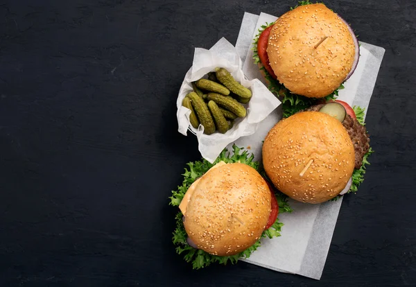 Trzy różne burger na białym papierze — Zdjęcie stockowe
