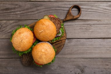 Ahşap tahta üzerinde üç farklı hamburger