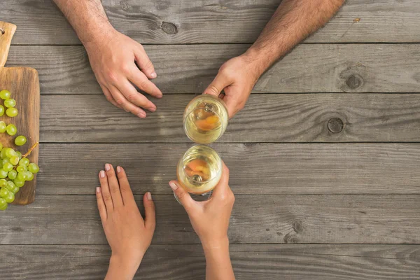 Coppia bicchieri di clinking con vino bianco seduto dietro ta di legno — Foto Stock