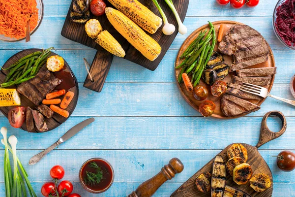 Steak de bœuf grillé aux légumes grillés sur table bleue en bois — Photo