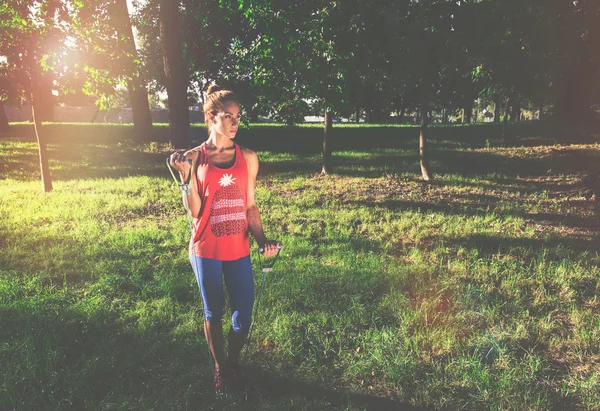 Молодая женщина делает спортивные упражнения с помощью экспандера в городском парке — стоковое фото