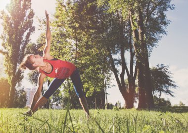 Genç kadın bir şehir parkı spor egzersizleri yapıyor