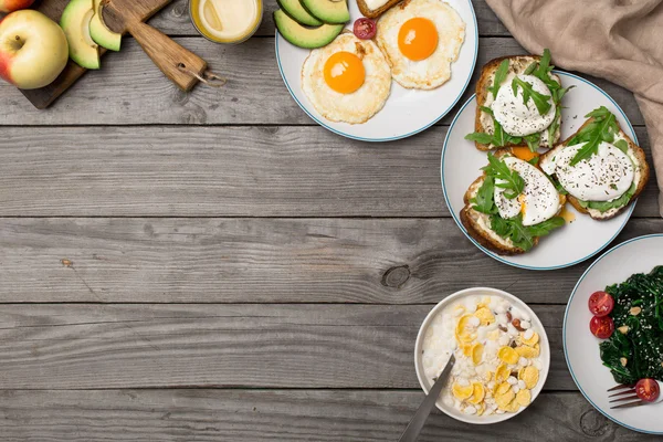 Desayuno útil de diferentes platos en mesa de madera —  Fotos de Stock