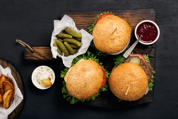 Hamburgers, cheeseburger with fries, sauce and pickles — Stock Photo, Image