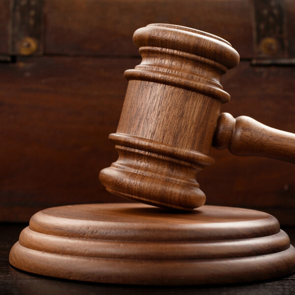 Judge hammer on brown wooden background