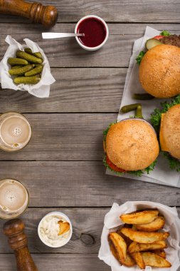 Farklı hamburger ve çizburger sosları, patates kızartması, turşu ile bir