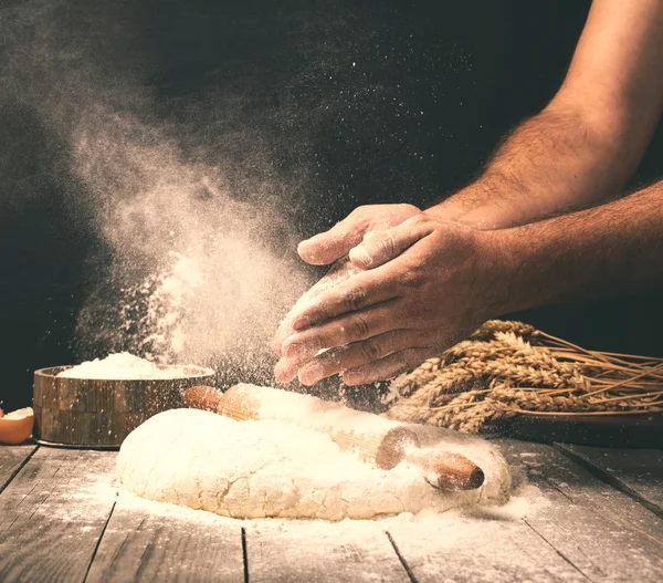 Uomo che prepara la pasta del pane su un tavolo di legno in una panetteria — Foto Stock