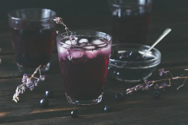 Glass with Blueberry Juice on dark wooden table — Stock Photo, Image