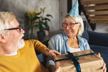 Mutlu yaşlılar hediyelerini verir. Neşeli son sınıf çifti birlikte tatil yapıyor. Doğum günü kavramı veya yıldönümü kavramı