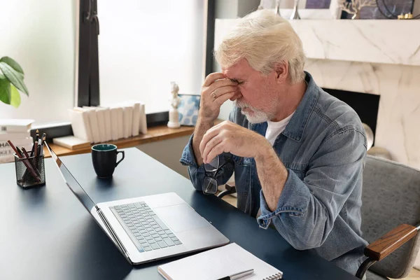 Trött Vuxen Man Som Lider Huvudvärk Vid Skrivbordet Medan Sitter — Stockfoto