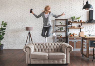 Genç güzel sarışın piyangoyu kazandı ve mutluluktan uçuyor.