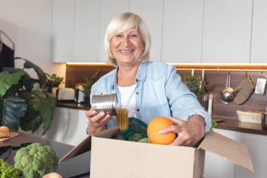 Yaşlı kadın gönüllülerden aldığı yemeklerle seviniyor.