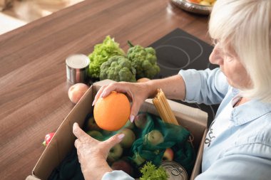 Emekli adam bir kutu yiyeceği parçalıyor. Üst görünüm