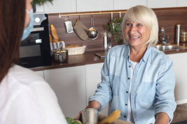 Gönüllü kız eve emeklilere yiyecek getirdi. Bağış konsepti