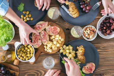 Üç kişinin kırsal ahşap masada birlikte yemek yediği en iyi manzara. Arkadaşların yemek konsepti.