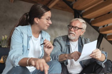 Sosyal hizmetler görevlisi yetişkin bekar bir erkeği ziyaret ediyor ve ona online ödemelerde yardım ediyor.