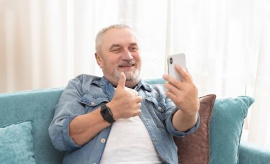 Çevrimiçi sohbete katılan yaşlı, modern bir adam.