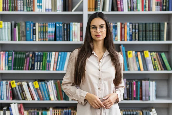 在图书馆书架上的背景下 漂亮的女学生 学习和教育概念 — 图库照片