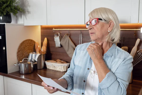 Una Donna Pensione Sta Cucina Con Lettera Con Rapporto Mensile — Foto Stock