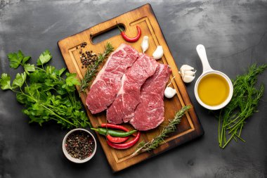 Koyu arkaplanda taze et ve üst görünüm için malzemeler var.