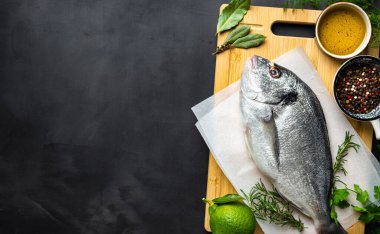 Koyu arka planda yemek pişirmek için malzemeli taze borabo balığı. Lezzetli ve sağlıklı yemekler.