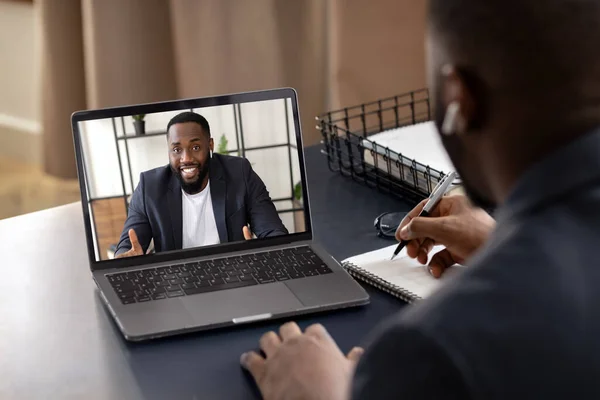 Happy young African American talking chat with to his coworker using laptop. Video call, self-isolation concept