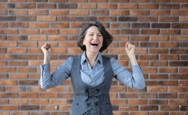 İş kıyafeti giymiş mutlu ve yaşlı bir kadının portresi. İyi haber konsepti