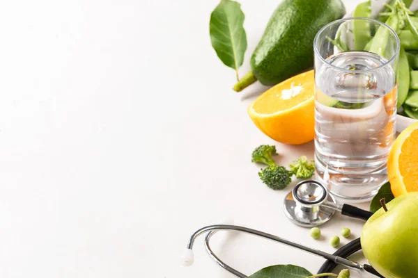 Set of products for diet food with medical Stethoscope and water on on white background. Healthy lifestyle concept