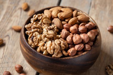 Tahta masadaki ahşap kasede çeşitli fındıkları kapat.