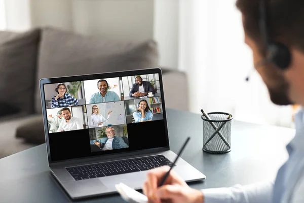 Meeting online concept. Young caucasian man using laptop for video calling with colleagues, employees in office, online meeting with many people together