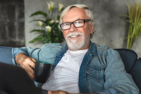 Portrét Usměvavého Šedesátníka Sedícího Gauči Šálkem Kávy Happy Pension — Stock fotografie