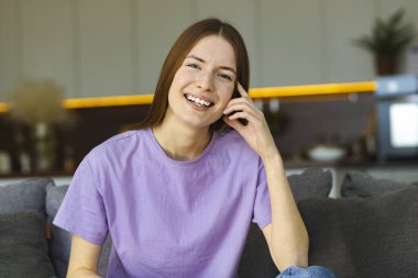 Evdeki kanepede oturan güzel beyaz kızın portresi, evde rahatlama, sağlıklı yaşam tarzı, gülümsemeler.