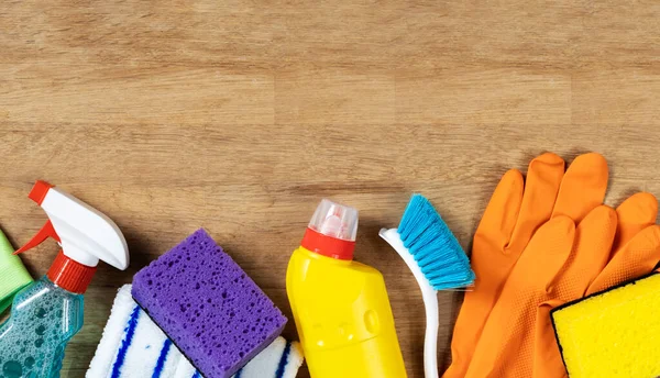 Cleaning concept. Set of cleaning supplies on wooden background with copy space, top view