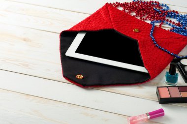 Beyaz ahşap arka planda tablet bilgisayar ile bir açık kırmızı bayanlar çanta