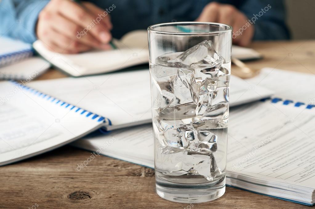glass of water on a wooden office desk