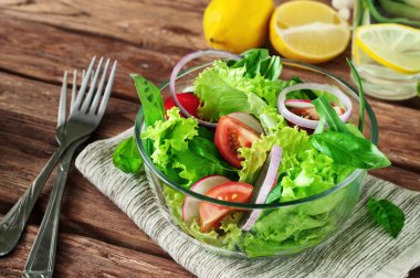 Vegetable salad in the bowl of glass on the wooden table