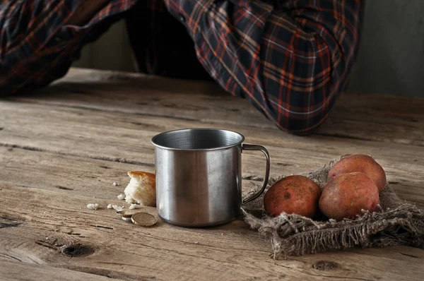 On the wooden table is a mug of water, a slice of bread, potatoe — Stock Photo, Image