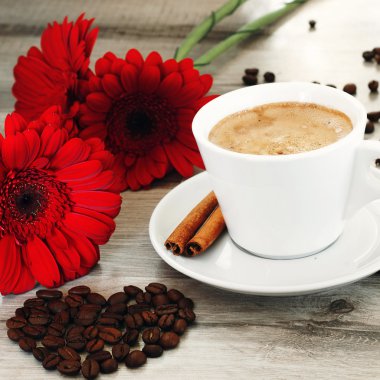 Coffee in a cup on a saucer with cinnamon sticks