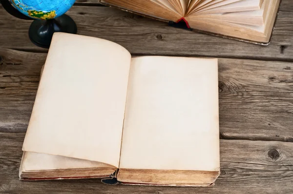 Apri vecchio libro con pagine bianche su tavolo di legno con globo chiuso — Foto Stock