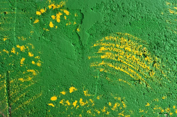 Background of brush strokes of yellow paint on a green wall — 스톡 사진