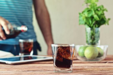 Bardak kola ahşap masa portre üzerinde ön planda