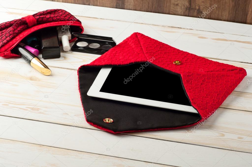 open red pen female handbag with tablet computer in a white wood