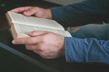 Man reading an old book closeup