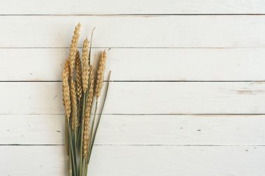 sheaf of spikelets of wheat on the wooden table closeup