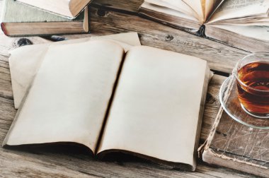 open book on wooden table with a cup of tea