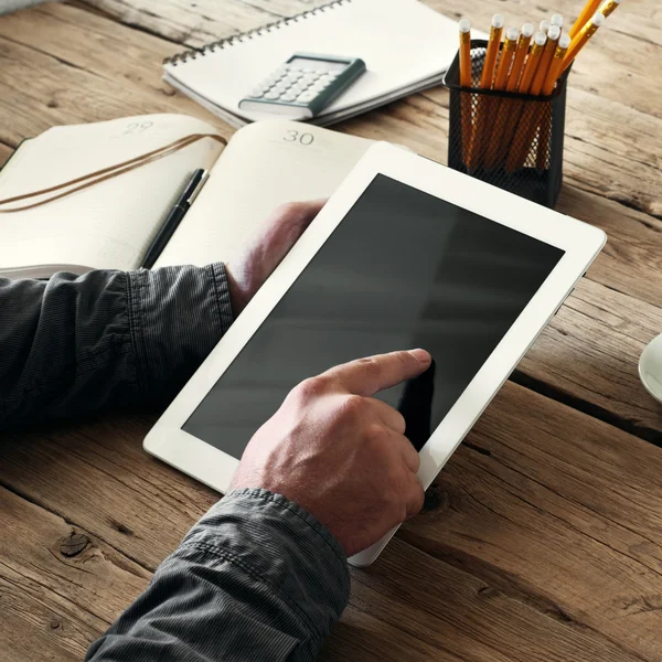 Men hand clicks on the tablet screen on wooden background — Stock Photo, Image