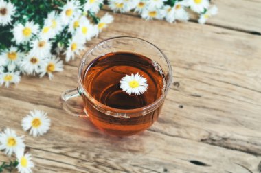 Cam bardak çay papatya bir buket ile