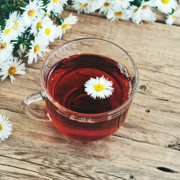 Glas kopje thee met een boeket van madeliefjes — Stockfoto