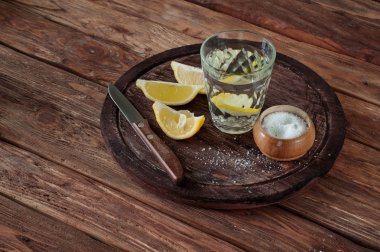 glass of tequila with lemon slices and salt