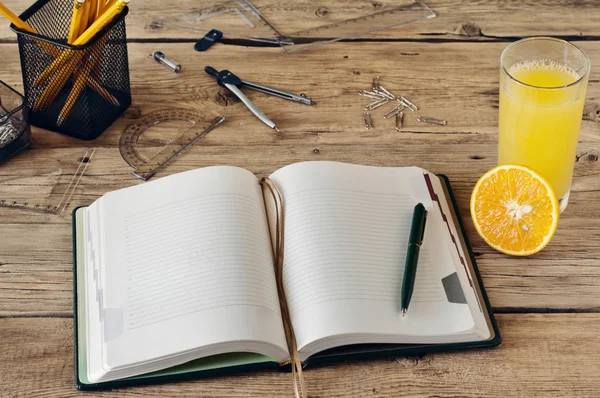 Bloc de notas en blanco con un vaso de jugo de naranja fresco — Foto de Stock